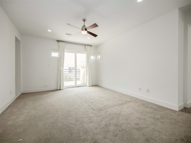 spare room featuring light carpet and ceiling fan