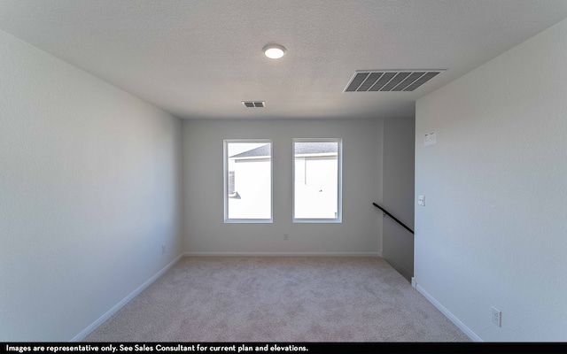 carpeted spare room featuring a textured ceiling