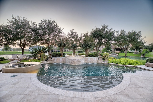 pool at dusk featuring a patio area and pool water feature