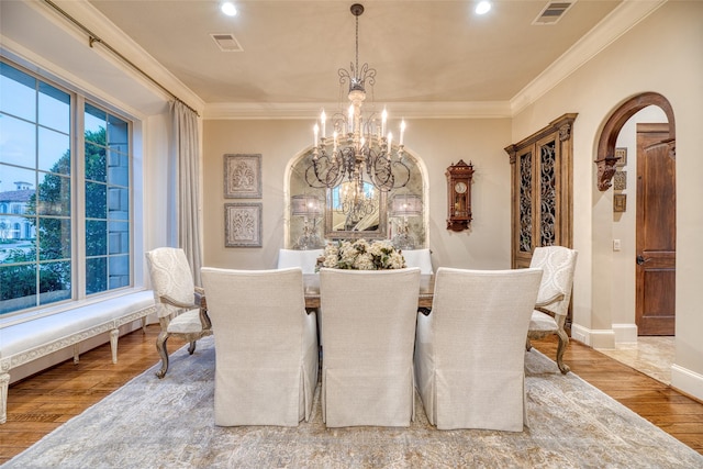 dining space featuring crown molding, hardwood / wood-style floors, and a notable chandelier