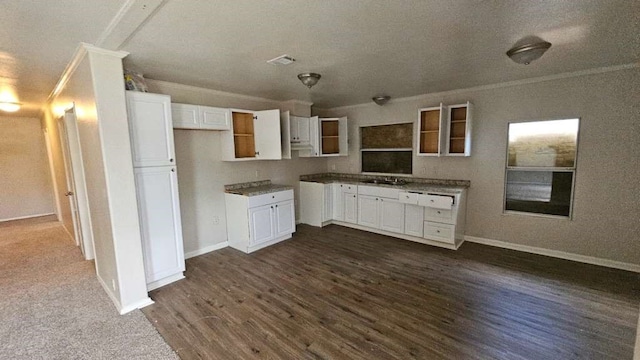 kitchen with a textured ceiling, ornamental molding, white cabinetry, and dark hardwood / wood-style floors