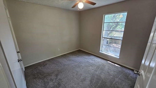 carpeted spare room featuring ceiling fan and a textured ceiling