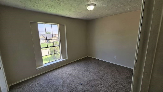 carpeted empty room with a textured ceiling