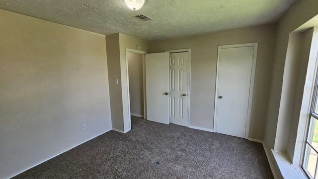 unfurnished bedroom with a textured ceiling and carpet flooring