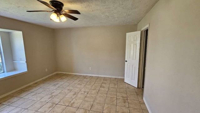 tiled empty room featuring a textured ceiling and ceiling fan