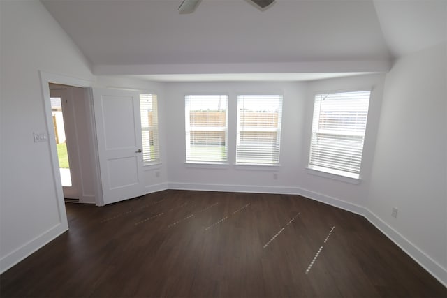 spare room with dark hardwood / wood-style flooring and vaulted ceiling