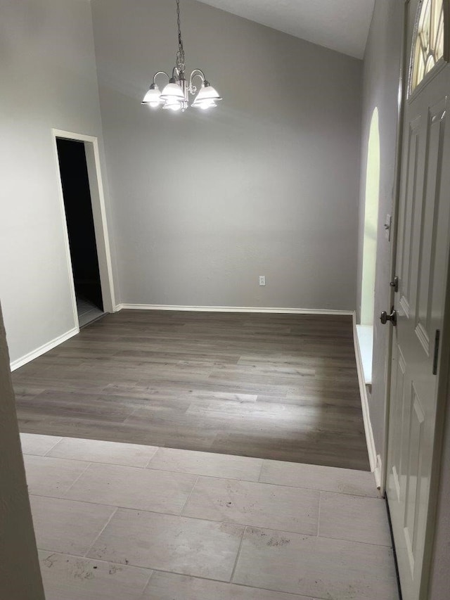 foyer entrance featuring a notable chandelier, baseboards, and wood finished floors