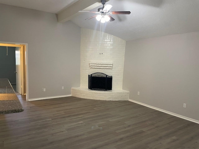 unfurnished living room featuring baseboards, dark wood finished floors, a ceiling fan, lofted ceiling with beams, and a fireplace