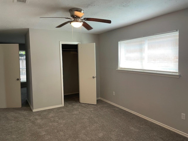 unfurnished bedroom featuring carpet, a closet, a textured ceiling, and baseboards