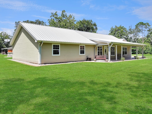 rear view of property featuring a lawn