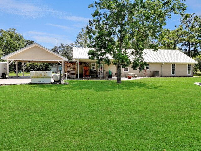 view of front of house featuring a carport, central air condition unit, and a front lawn