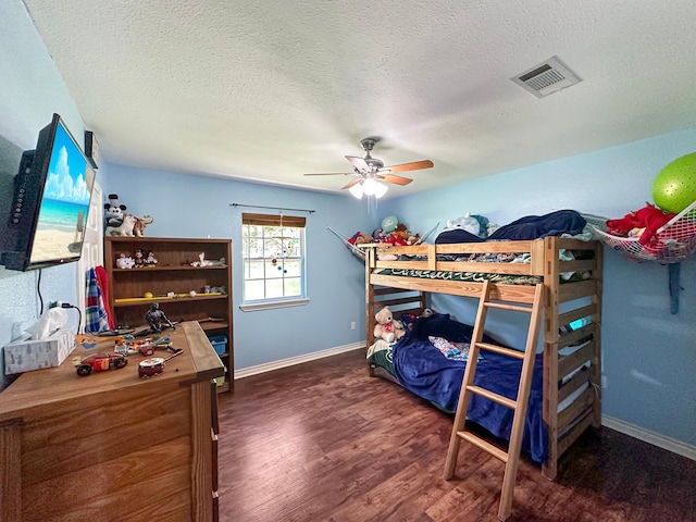 bedroom with a textured ceiling, wood-type flooring, and ceiling fan