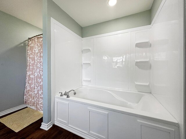 bathroom with shower / bath combo with shower curtain and wood-type flooring