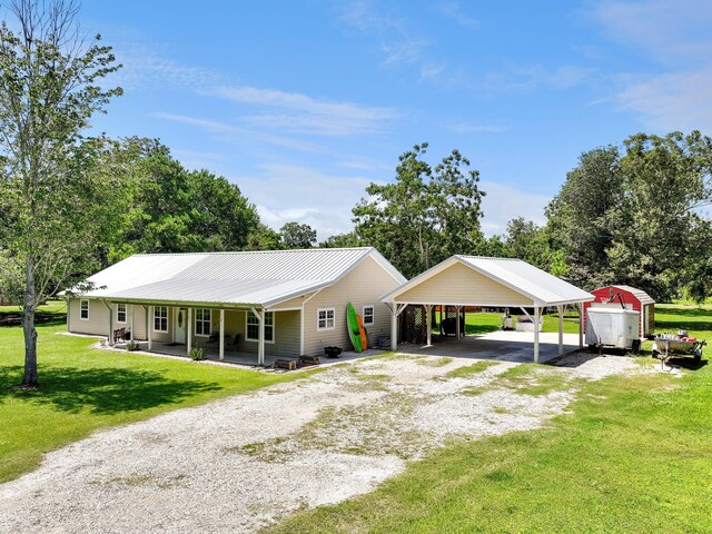 ranch-style home featuring a carport, a porch, and a front yard