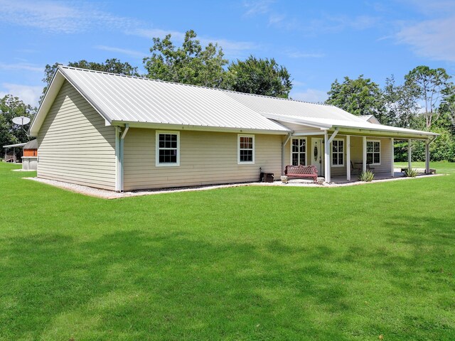 rear view of property featuring a yard