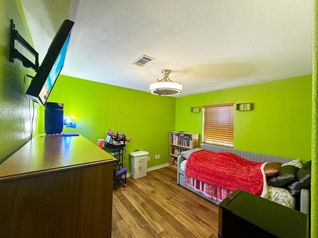 bedroom featuring a textured ceiling and hardwood / wood-style flooring