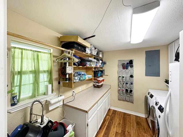 washroom with washing machine and dryer, a textured ceiling, dark hardwood / wood-style flooring, and electric panel