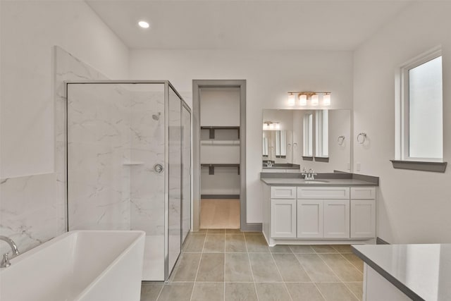 bathroom with plus walk in shower, vanity, and tile patterned flooring