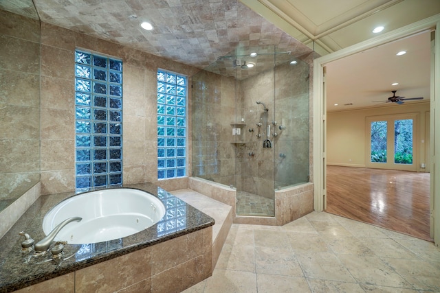 bathroom with shower with separate bathtub, ceiling fan, tile walls, and hardwood / wood-style flooring