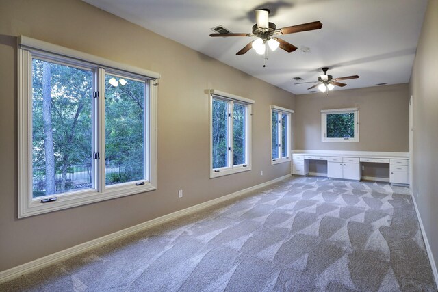 unfurnished living room featuring light carpet and ceiling fan