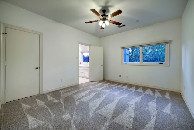 unfurnished bedroom featuring light carpet, ceiling fan, and connected bathroom