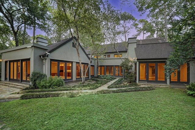 exterior space featuring french doors and a lawn