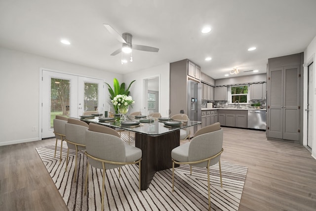 dining area with ceiling fan, light hardwood / wood-style flooring, and sink