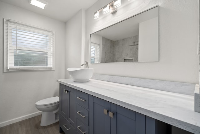 bathroom featuring walk in shower, hardwood / wood-style floors, vanity, and toilet