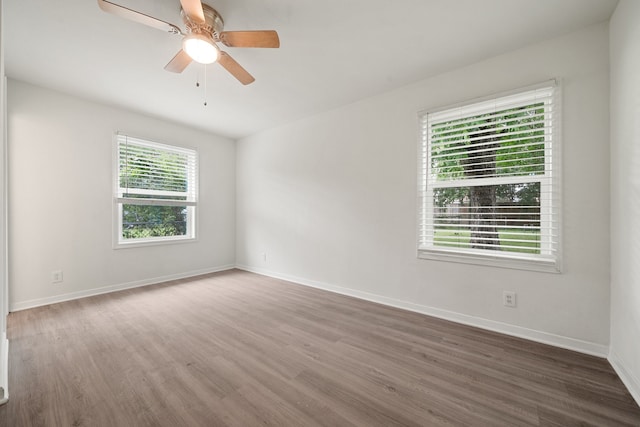 empty room with dark hardwood / wood-style floors and ceiling fan