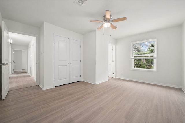 unfurnished bedroom with ceiling fan, light hardwood / wood-style floors, and a closet