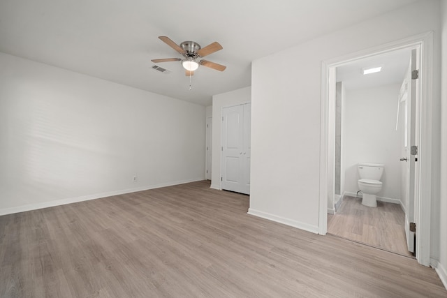 unfurnished bedroom with connected bathroom, ceiling fan, a closet, and light hardwood / wood-style floors