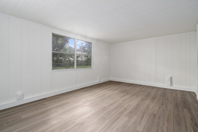 empty room featuring hardwood / wood-style flooring and wooden walls