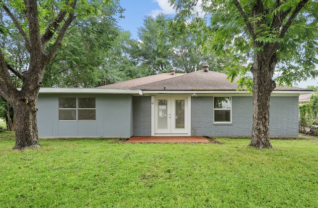 rear view of house with french doors and a yard