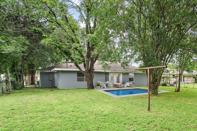 rear view of house featuring an outdoor living space, a yard, and a patio