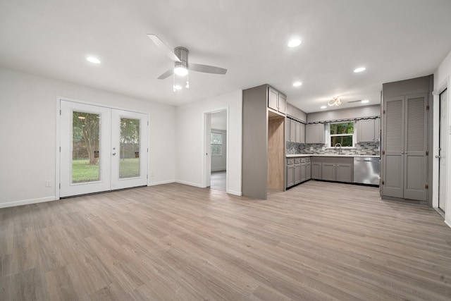 kitchen featuring dishwasher, light wood-type flooring, gray cabinets, and a healthy amount of sunlight