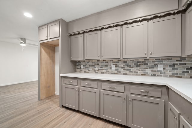 kitchen with gray cabinetry, tasteful backsplash, and light hardwood / wood-style flooring