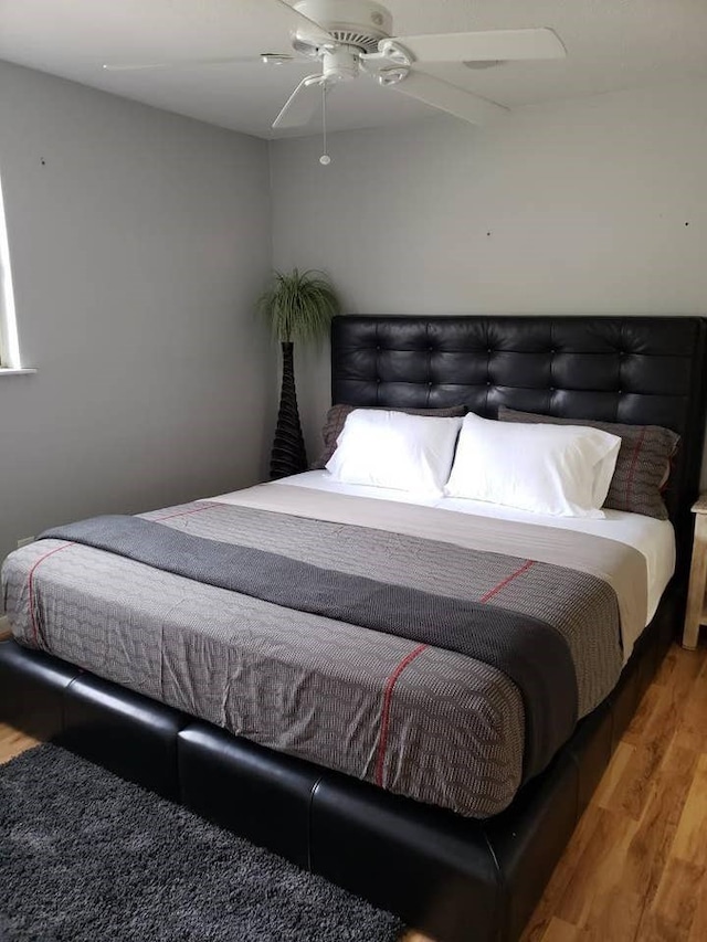 bedroom with ceiling fan and hardwood / wood-style floors