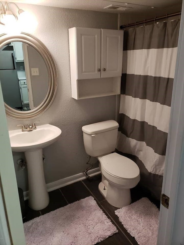 bathroom featuring sink, tile patterned floors, and toilet