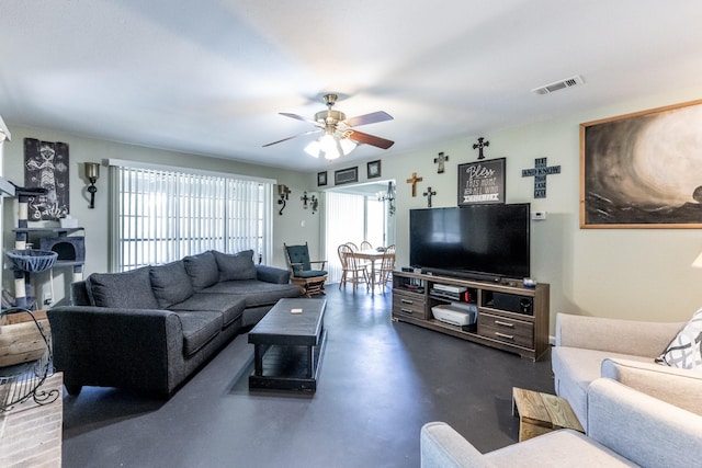 living area featuring concrete flooring, ceiling fan, and visible vents