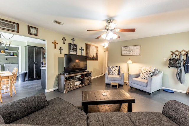 living room featuring baseboards, visible vents, washer / clothes dryer, and concrete flooring