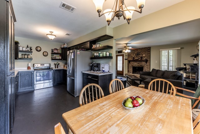 dining room featuring a brick fireplace, visible vents, and ceiling fan with notable chandelier