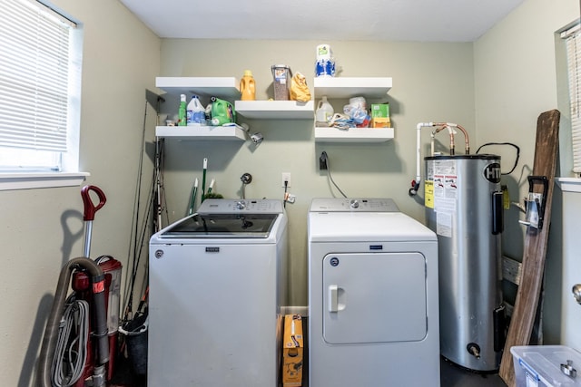 clothes washing area with laundry area, water heater, and washing machine and clothes dryer