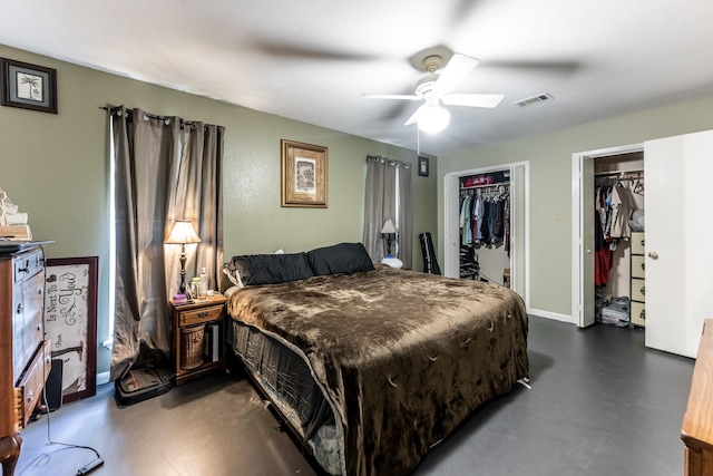 bedroom with ceiling fan, visible vents, baseboards, two closets, and finished concrete floors