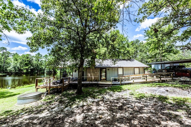 rear view of property featuring a deck with water view