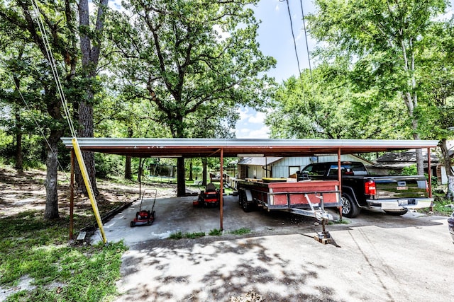 view of parking featuring concrete driveway and a detached carport