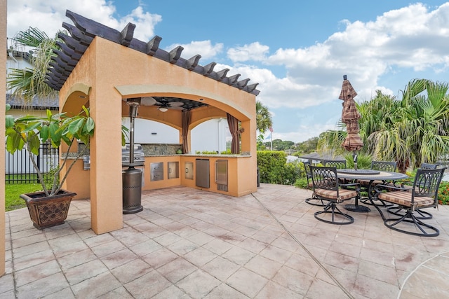 view of patio with an outdoor bar, area for grilling, ceiling fan, and a grill