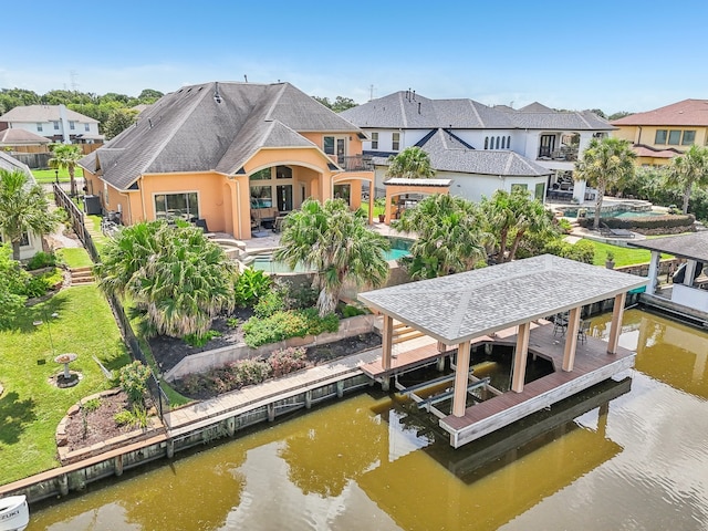 view of dock with a patio, a water view, and a yard