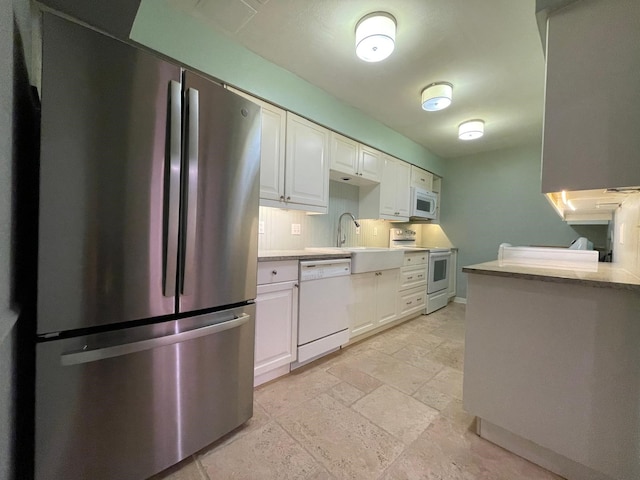 kitchen featuring white cabinetry, white appliances, sink, light tile patterned floors, and backsplash