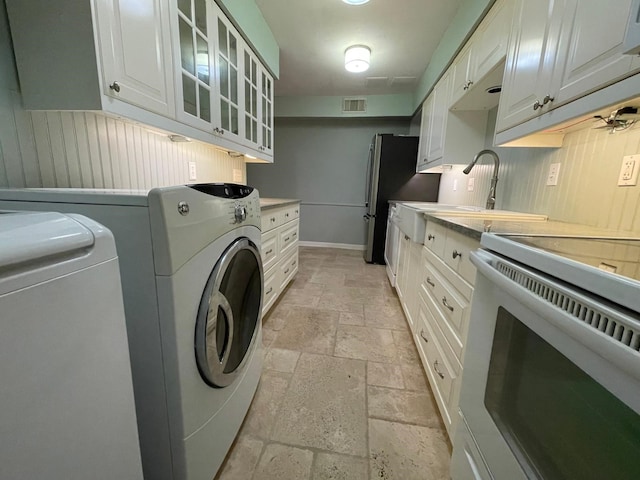 laundry room with washer and dryer, sink, and light tile patterned floors