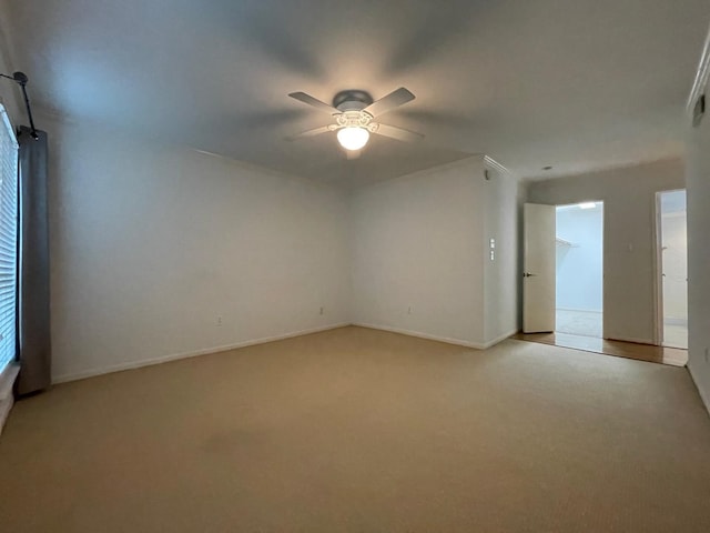 spare room featuring light colored carpet and ceiling fan